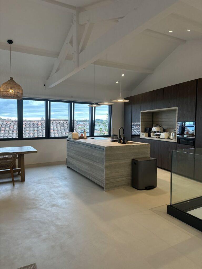Cuisine moderne en béton ciré avec vue panoramique.